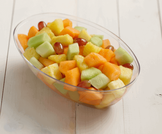 A bowl of mixed fruit including cantaloupe, honeydew, grape, and pineapple.
