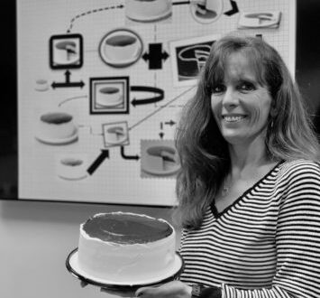 Ukrop's team member Sharon Washburn holding a Black and White Cake.